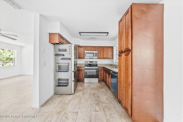 133 Lee Rd, Melbourne, FL 32904 - kitchen with appliances with stainless steel finishes, brown cabinets, a sink, a ceiling fan, and baseboards
