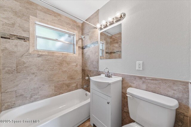 133 Lee Rd, Melbourne, FL 32904 - full bath with tile walls,  shower combination, toilet, vanity, and a textured wall