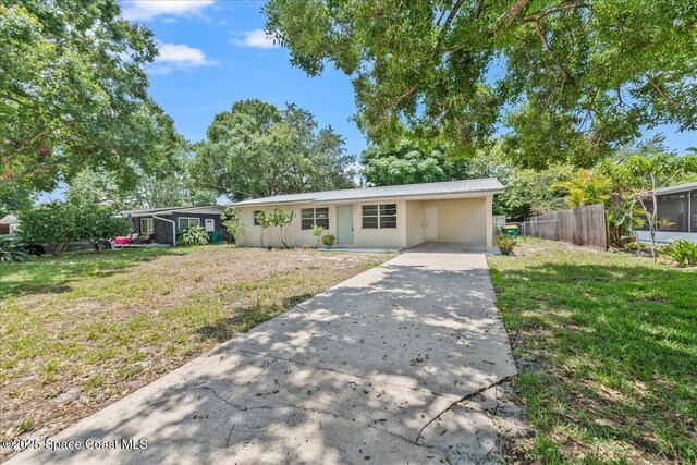 133 Lee Rd, Melbourne, FL 32904 - ranch-style house featuring concrete driveway, an attached carport, metal roof, and stucco siding