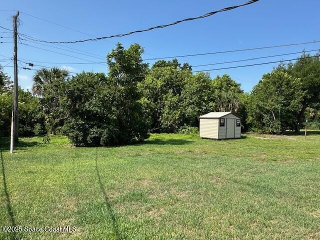 view of grassy yard with a storage shed and an outdoor structure