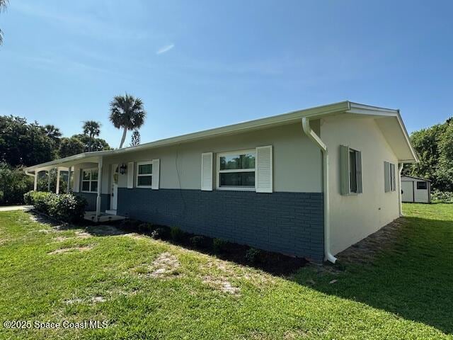 view of side of home with a yard and stucco siding