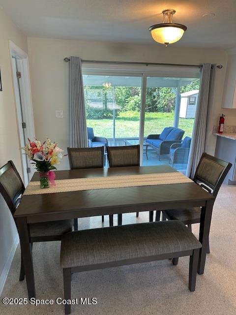 dining space with light colored carpet and baseboards