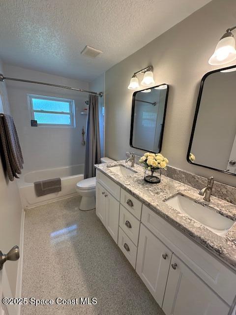 bathroom featuring toilet, a textured ceiling, shower / tub combo, and double vanity