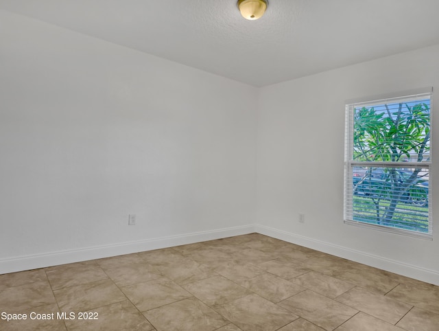 unfurnished room featuring baseboards and a textured ceiling