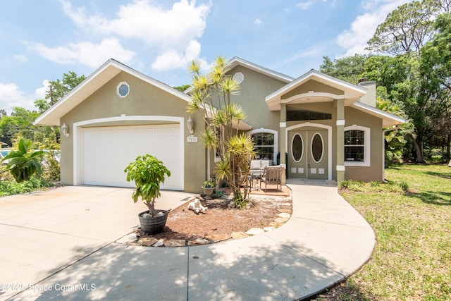 7030 Livingstone Ln, Melbourne, FL 32904 - mediterranean / spanish home with stucco siding, concrete driveway, a chimney, an attached garage, and a front yard