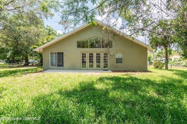 7030 Livingstone Ln, Melbourne, FL 32904 - back of property with stucco siding, a lawn, french doors, and a patio