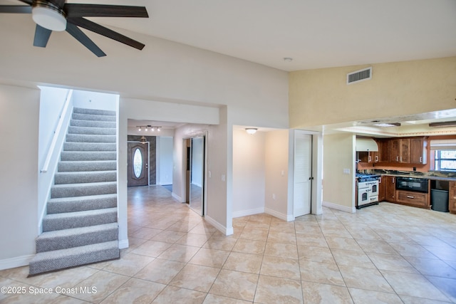 5510 Howell Branch Rd, Winter Park, FL 32792 - unfurnished living room with stairs, a ceiling fan, light tile patterned floors, high vaulted ceiling, and baseboards