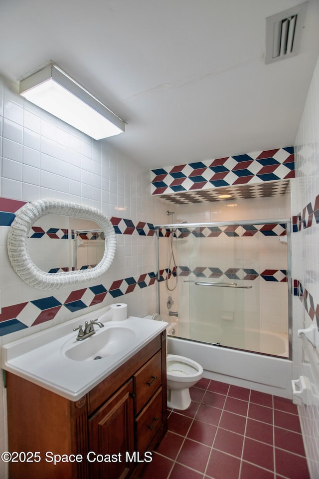 5510 Howell Branch Rd, Winter Park, FL 32792 - full bath with tile walls, vanity, combined bath / shower with glass door, toilet, and tile patterned flooring