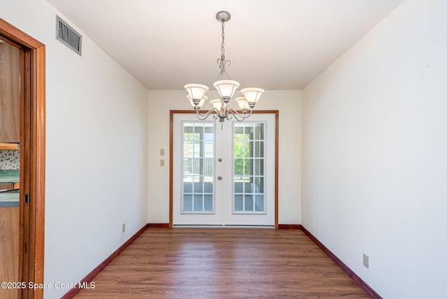 174 Peckham St NE, Palm Bay, FL 32907 - unfurnished dining area featuring a chandelier, wood finished floors, french doors, and baseboards