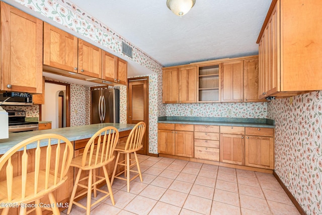 174 Peckham St NE, Palm Bay, FL 32907 - kitchen featuring wallpapered walls, appliances with stainless steel finishes, open shelves, light tile patterned flooring, and baseboards