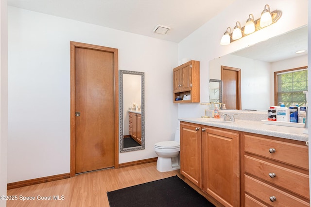 174 Peckham St NE, Palm Bay, FL 32907 - bathroom featuring vanity, toilet, wood finished floors, and baseboards