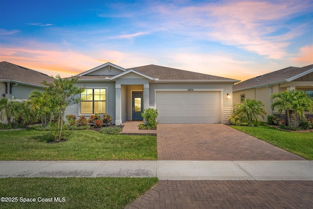8854 Alister Dr, Melbourne, FL 32940 - ranch-style home featuring decorative driveway, a garage, stucco siding, and a yard