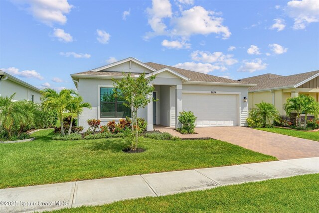 8854 Alister Dr, Melbourne, FL 32940 - ranch-style home with decorative driveway, an attached garage, stucco siding, and a front lawn