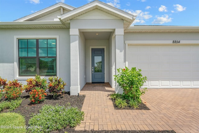 8854 Alister Dr, Melbourne, FL 32940 - doorway to property featuring stucco siding and an attached garage