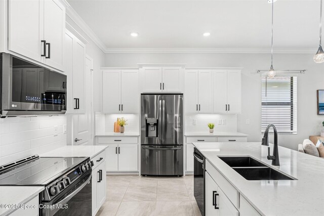 8854 Alister Dr, Melbourne, FL 32940 - kitchen with stainless steel appliances, a sink, crown molding, white cabinets, and decorative backsplash