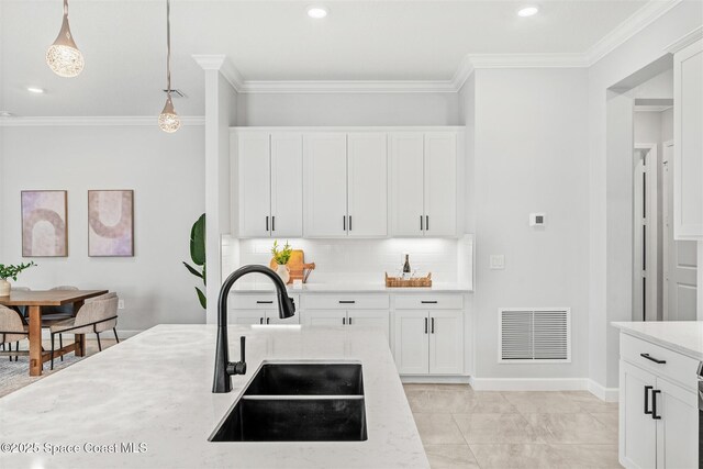 8854 Alister Dr, Melbourne, FL 32940 - kitchen with a sink, crown molding, decorative backsplash, pendant lighting, and white cabinets