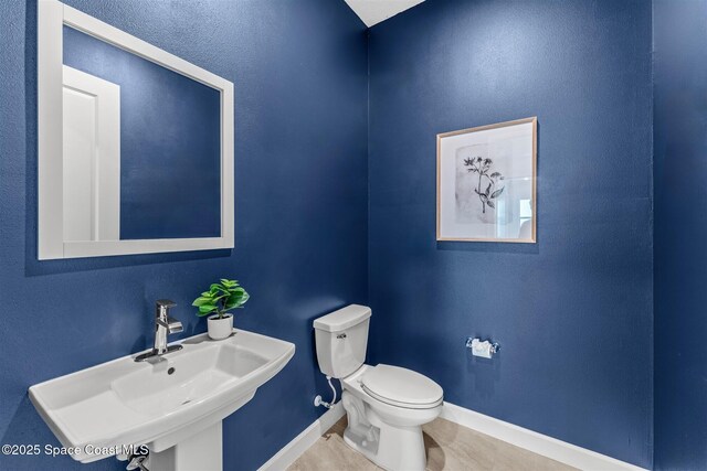 8854 Alister Dr, Melbourne, FL 32940 - bathroom with a sink, toilet, baseboards, and tile patterned floors