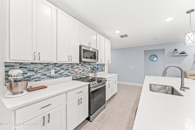 916 Corbin Cir SW, Palm Bay, FL 32908 - kitchen with stainless steel appliances, a sink, tasteful backsplash, light countertops, and white cabinets