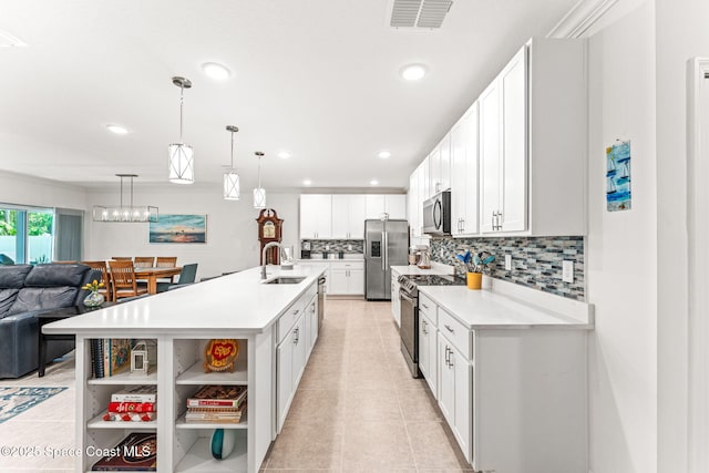 916 Corbin Cir SW, Palm Bay, FL 32908 - kitchen featuring appliances with stainless steel finishes, a sink, open shelves, open floor plan, and light countertops