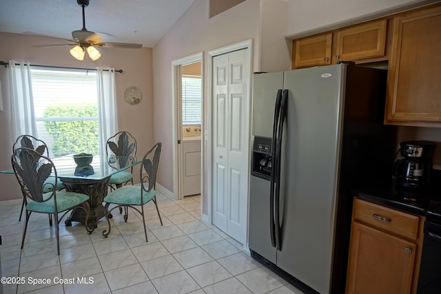 kitchen featuring stainless steel fridge with ice dispenser, washer / dryer, lofted ceiling, brown cabinetry, and dark countertops