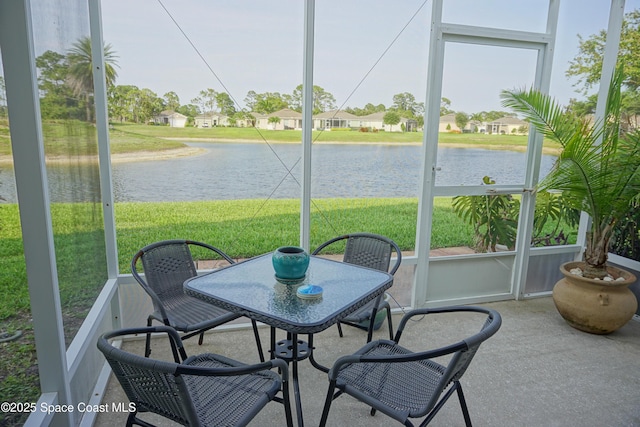 sunroom / solarium featuring a water view and healthy amount of natural light