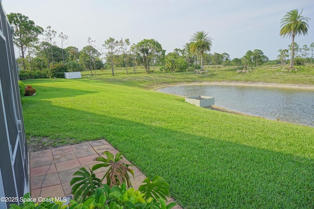 view of green lawn featuring a water view