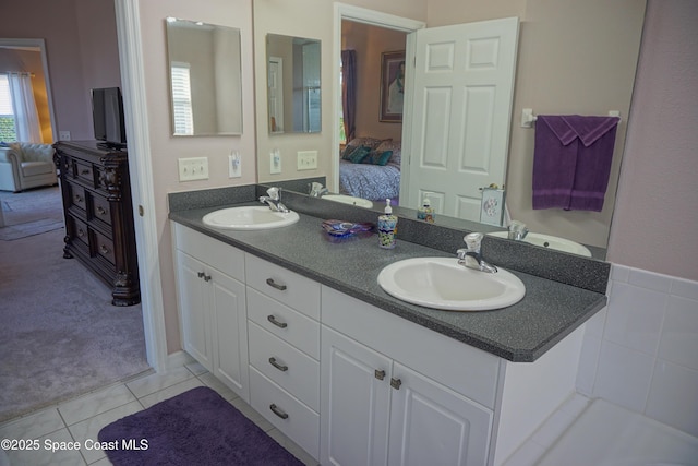 ensuite bathroom with double vanity and tile patterned flooring