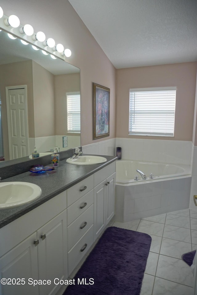 full bath with a bath, tile patterned flooring, and double vanity