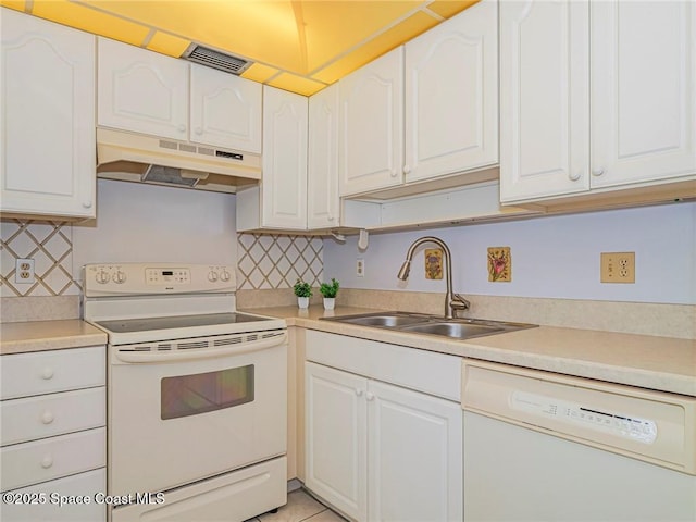 18 Vista Palm Ln Unit 102, Vero Beach, FL 32962 - kitchen featuring white appliances, under cabinet range hood, a sink, and white cabinets