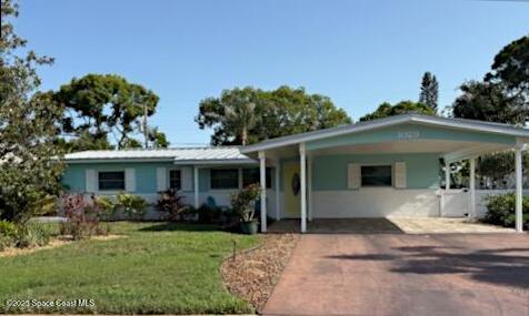 1029 Palmer Rd, Rockledge, FL 32955 - ranch-style home featuring a front lawn, driveway, and a carport