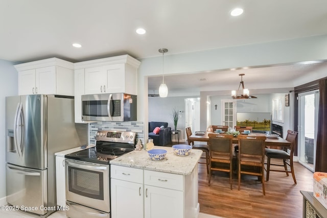 1029 Palmer Rd, Rockledge, FL 32955 - kitchen featuring stainless steel appliances, open floor plan, tasteful backsplash, white cabinetry, and light stone counters