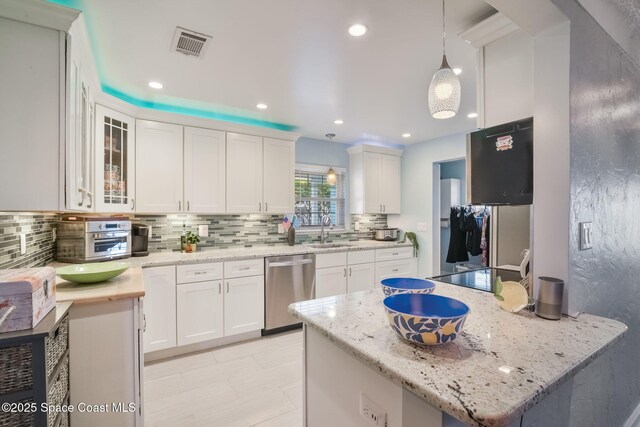 1029 Palmer Rd, Rockledge, FL 32955 - kitchen with stainless steel dishwasher, white cabinetry, tasteful backsplash, and recessed lighting
