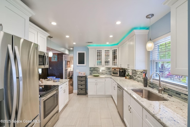 1029 Palmer Rd, Rockledge, FL 32955 - kitchen with stainless steel appliances, decorative backsplash, white cabinets, and recessed lighting