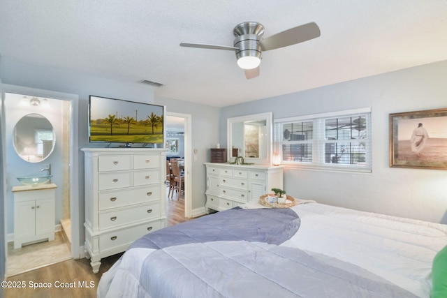 1029 Palmer Rd, Rockledge, FL 32955 - bedroom with light wood finished floors, ensuite bathroom, and a ceiling fan