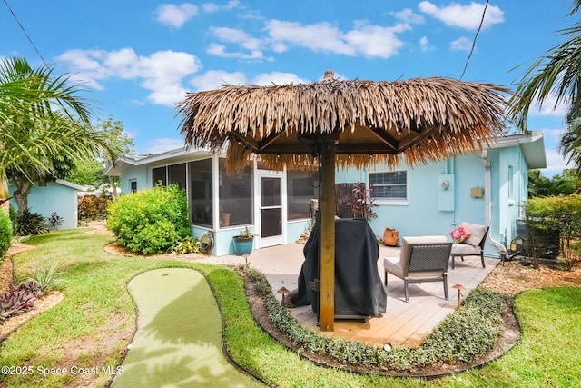 1029 Palmer Rd, Rockledge, FL 32955 - rear view of house featuring a sunroom, a putting green, and stucco siding