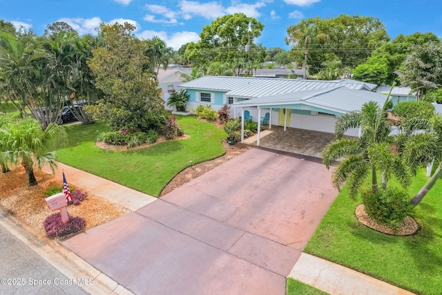 1029 Palmer Rd, Rockledge, FL 32955 - single story home featuring concrete driveway, a front yard, an attached carport, stucco siding, and a metal roof