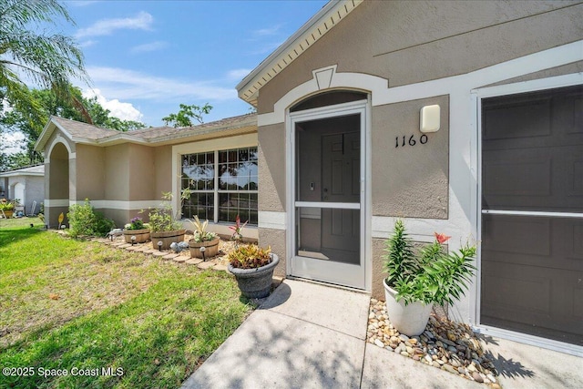 1160 Waco Blvd SE, Palm Bay, FL 32909 - doorway to property featuring stucco siding and a yard