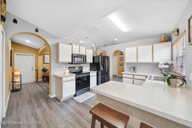 1160 Waco Blvd SE, Palm Bay, FL 32909 - kitchen featuring black electric range oven, arched walkways, fridge with ice dispenser, vaulted ceiling, and light wood-style flooring