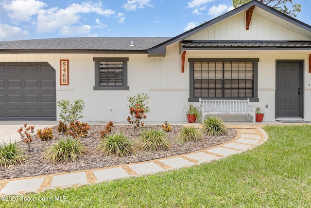 5460 Holden Rd, Cocoa, FL 32927 - view of front facade with brick siding, covered porch, a garage, and board and batten siding