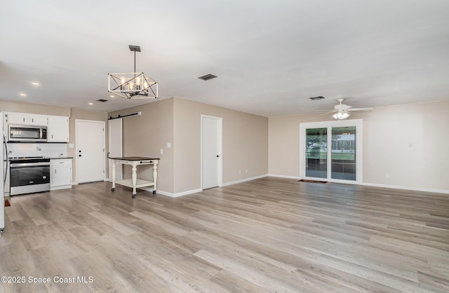 5460 Holden Rd, Cocoa, FL 32927 - unfurnished living room featuring a barn door, ceiling fan, baseboards, a chandelier, and recessed lighting