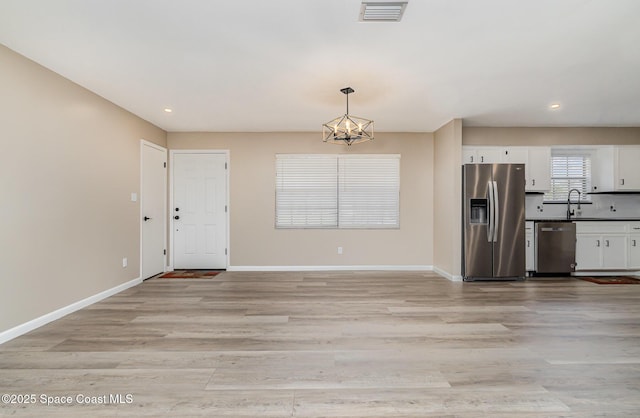 5460 Holden Rd, Cocoa, FL 32927 - kitchen with appliances with stainless steel finishes, a chandelier, white cabinetry, baseboards, and recessed lighting