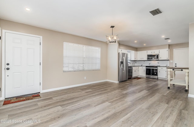 5460 Holden Rd, Cocoa, FL 32927 - kitchen featuring stainless steel appliances, a chandelier, white cabinets, baseboards, and recessed lighting