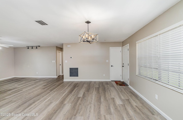 5460 Holden Rd, Cocoa, FL 32927 - unfurnished living room with a chandelier, light wood finished floors, and baseboards
