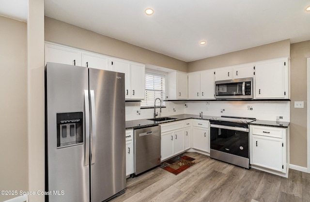 5460 Holden Rd, Cocoa, FL 32927 - kitchen with stainless steel appliances, dark countertops, a sink, wood finished floors, and recessed lighting