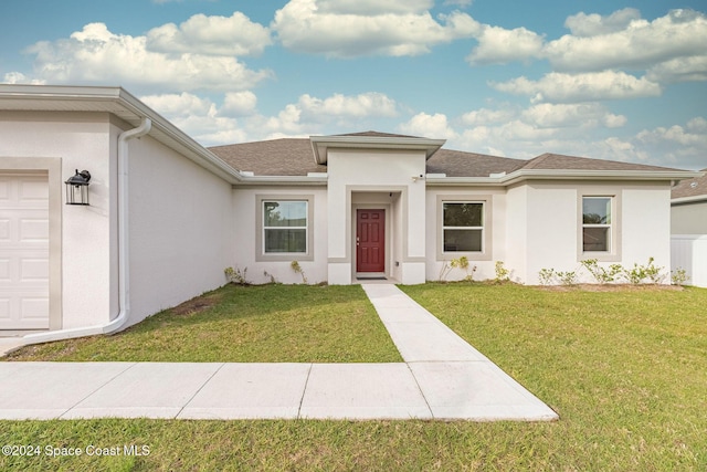 1717 Dalroy St NW, Palm Bay, FL 32907 - view of front of home with stucco siding, a front yard, roof with shingles, and an attached garage