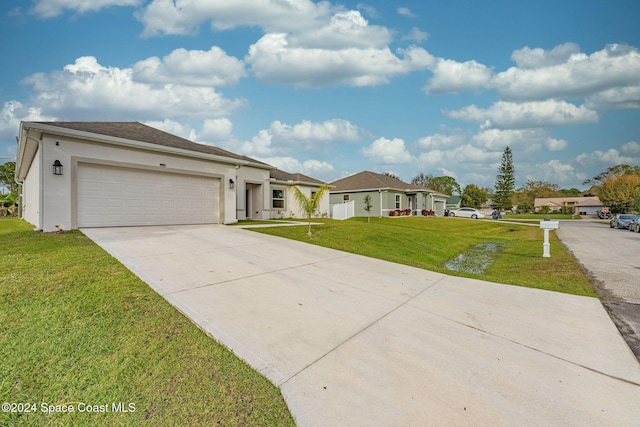 1717 Dalroy St NW, Palm Bay, FL 32907 - view of front of house featuring driveway, a front lawn, a garage, and stucco siding