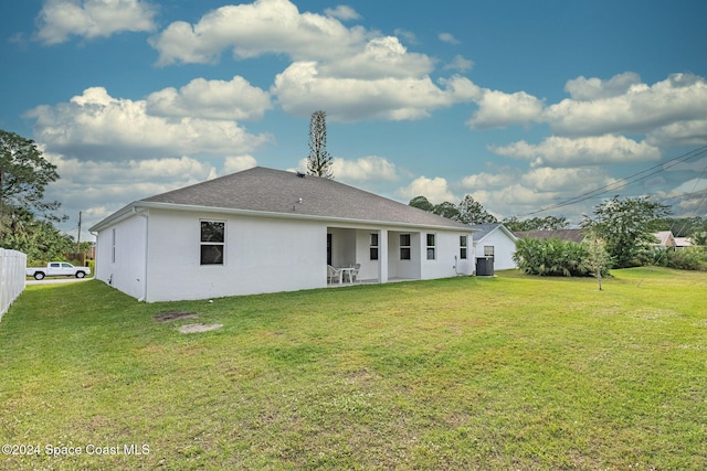 1717 Dalroy St NW, Palm Bay, FL 32907 - rear view of property featuring a lawn, stucco siding, and a shingled roof