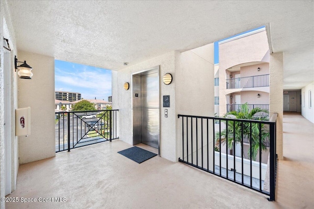 121 Lancha Cir Unit 206, Indian Harbour Beach, FL 32937 - entrance to property featuring elevator, stucco siding, and a balcony