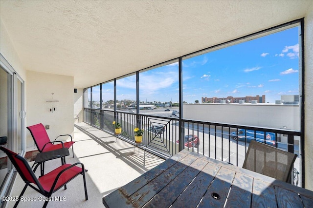 121 Lancha Cir Unit 206, Indian Harbour Beach, FL 32937 - sunroom featuring a textured ceiling, a view of city, a wall of windows, and carpet flooring