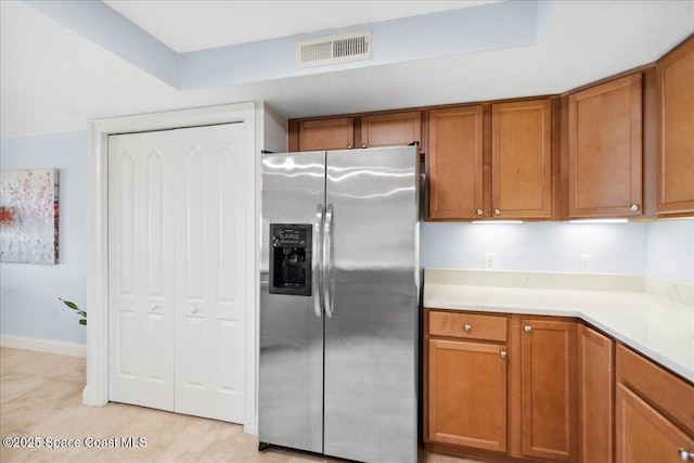 121 Lancha Cir Unit 206, Indian Harbour Beach, FL 32937 - kitchen with stainless steel fridge with ice dispenser, brown cabinetry, light countertops, and light tile patterned floors